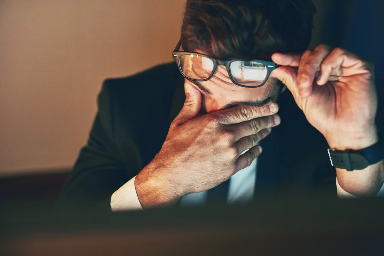 man having eye strain due to looking at screens for too long