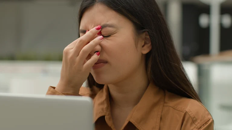 woman having a tension headache due to staring at a screen all day